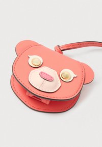 Ροζ θήκη σε σχήμα αρκούδας από συνθετικό υλικό. Διαθέτει διακοσμητικά χρυσά κουμπιά, πολυεπίπεδες υφές και μικρή λαβή για μεταφορά.