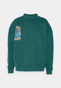 Groene katoenen sweatshirt met een hoge hals, voorzien van een kleurrijke grafische patch op de linkerborst. Ribbelboorden en onderkant bieden structuur.