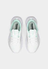 White athletic shoes with a textured upper, mint green accents, and a lace-up design. The sole is white with subtle patterns.