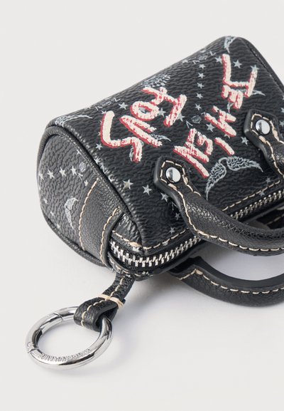 Μίνι τσάντα από μαύρο δερματίνη με υφή, με λευκό και κόκκινο κείμενο «STAY INSANE», σχέδια αστεριών, ραμμένες λαβές και προσαρτημένο ασημένιο μπρελόκ.