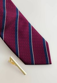 Maroon tie with a textured pattern, featuring blue and white stripes. Accompanied by a gold tie clip with a sleek, polished finish.