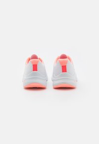 Zapatillas deportivas blancas con acentos en rosa, que cuentan con una parte superior texturizada, talón acolchado y una suela flexible. La vista trasera destaca los detalles de diseño.