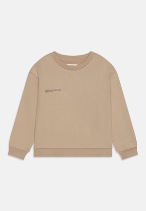 Sudadera beige de manga larga, con cuello redondo y dobladillo cosido. Presenta un pequeño detalle de texto impreso en la parte frontal. Textura suave.