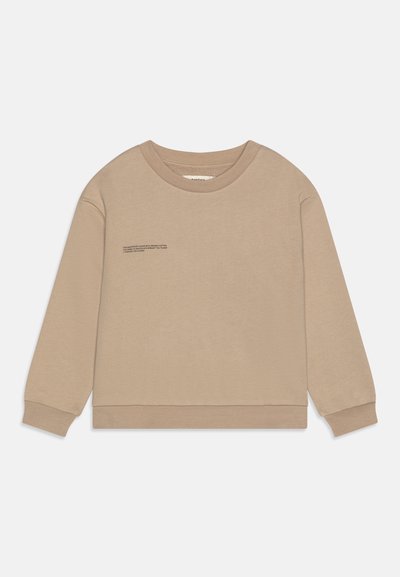 Sudadera beige de manga larga, con cuello redondo y dobladillo cosido. Presenta un pequeño detalle de texto impreso en la parte frontal. Textura suave.