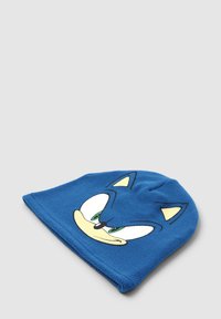 Niebieska czapka z polaru z wzorem twarzy postaci z kreskówki, z dużymi białymi oczami i zielonymi akcentami, miękka tekstura i zaokrąglony kształt.