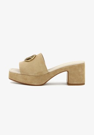 Sandali platform beige in suede con tacco a blocco, caratterizzati da una fascia larga e un accento circolare dorato nella parte anteriore. Superficie liscia e strutturata.