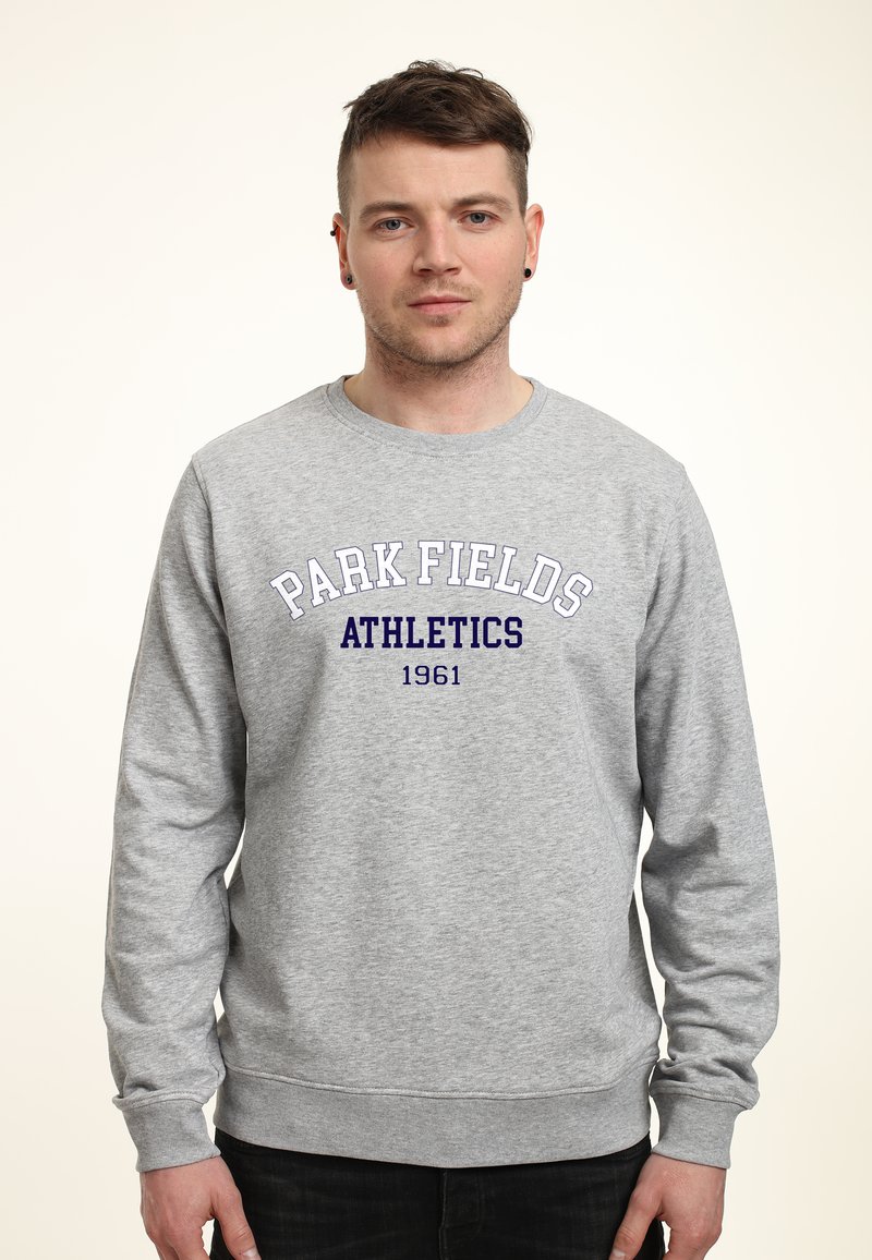 Szary sweter z bawełny, z ribbowymi mankietami i dołem. Na przodzie w ciemnoniebieskim kolorze znajduje się napis "PARK FIELDS ATHLETICS 1961".