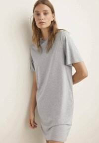 Grå bomulds T-shirt kjole med korte ærmer, afslappet pasform og rund halsudskæring. Glat tekstur og minimalisk design.