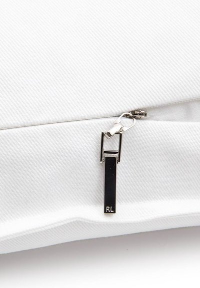 Λευκό υφασμάτινο ύφασμα με ασημένιο φερμουάρ που είναι μερικώς ανοιχτό, με μια μαύρη ορθογώνια λαβή έλξης χαραγμένη με μικρά γράμματα "RL".