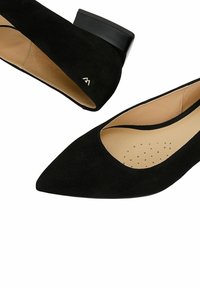 Černé semišové dámské boty s špičatou špičkou a nízkým podpatkem, béžovou vnitřní podšívkou a malými perforacemi ve stélce pro prodyšnost.