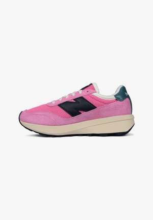 Pink sneaker with mesh and suede materials, featuring a black logo, white laces, and a cream-colored midsole. Rubber outsole for traction.
