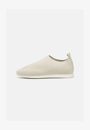 Μπεζ πλεκτό παπούτσι slip-on με χαμηλό προφίλ, υφημένο πάνω μέρος και ευέλικτη σόλα. Διαθέτει πλεκτό σχέδιο γύρω από τον αστράγαλο για άνεση.