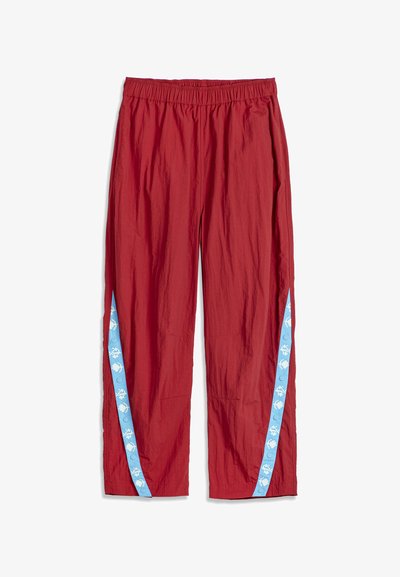 Pantalon rouge léger avec taille élastique et bandes latérales bleues ornées de motifs floraux blancs et de boutons-pression.