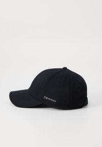 Căciulă de baseball neagră, realizată din țesătură twill, cu o vizieră curbată și logo-ul brodat "Calvin Klein" pe lateral. Design cu o potrivire standard.