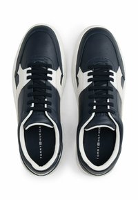 Granatowe skórzane sneakersy z białymi akcentami, okrągłym noskiem i sznurowanym zapięciem. Posiada perforacje oraz wyściełany kołnierz dla wygody.