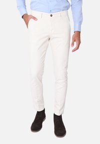 Chinos bianchi in misto cotone con una vestibilità slim, dotati di chiusura a bottone, passanti per cintura, tasche laterali e una texture liscia.