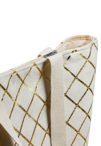 Canvas-Shopper mit beigem Hintergrund, versehen mit einem goldenen geometrischen Muster und einem oberen Reißverschluss. Inklusive stabilen Stoffgriffen.