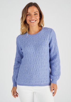 Suéter de punto de color púrpura claro con un patrón de ondas texturizado, cuello redondo y mangas largas. Se lleva con pantalones blancos.