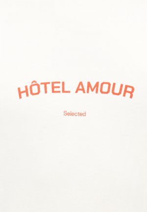 Valge kangas oranži tekstiga „HÔTEL AMOUR“, kaarekujul ülal, alla keskele paigutatud väiksem „Selected“.