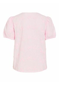 Blouse rose clair à manches courtes avec manches bouffantes et petites appliques florales 3D réparties uniformément sur le tissu.