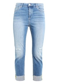 Vaqueros de mezclilla azul claro con un diseño desgastado, que presentan dos rasgones en las rodillas, dobladillos con vuelta y costuras amarillas en contraste en la cinturilla.