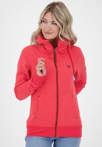 Red zip-up hoodie made of soft fabric, featuring a high collar, black heart logo, and two side pockets with black accents.