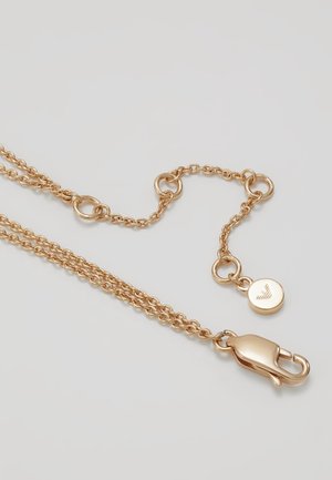 Guldtonet kædehalskæde med justerbare led, karabinlås og lille rund vedhæng med indgraveret logo.