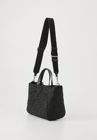 Black quilted handbag with floral pattern, dual top handles, and adjustable fabric strap. Silver hardware accents enhance the design.