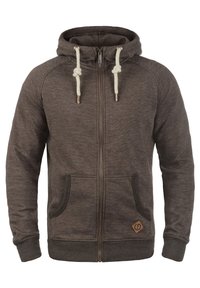 Bruine zip-up hoodie gemaakt van zachte stof, met een trekkoordkap, twee voorzakken en een klein logo op de linkerbovenhoek.