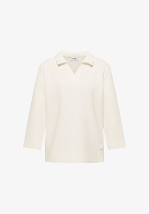 Kremfarvet ribstrikket langærmet top med V-hals og løs pasform, med et lille rektangulært logo-patch nær sømmen.