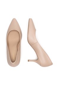 Zapatos de tacón alto de cuero color nude con punta puntiaguda y tacón de aguja delgado. Textura suave, acentos mínimos y diseño elegante.