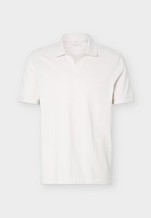 Tricou polo alb, cu mâneci scurte, guler moale și un logo mic și discret pe pieptul stâng.