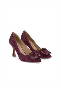 Escarpins en daim violet à bout pointu, dotés d'une grande boucle décorative ornée de pierres précieuses multicolores sur le devant.