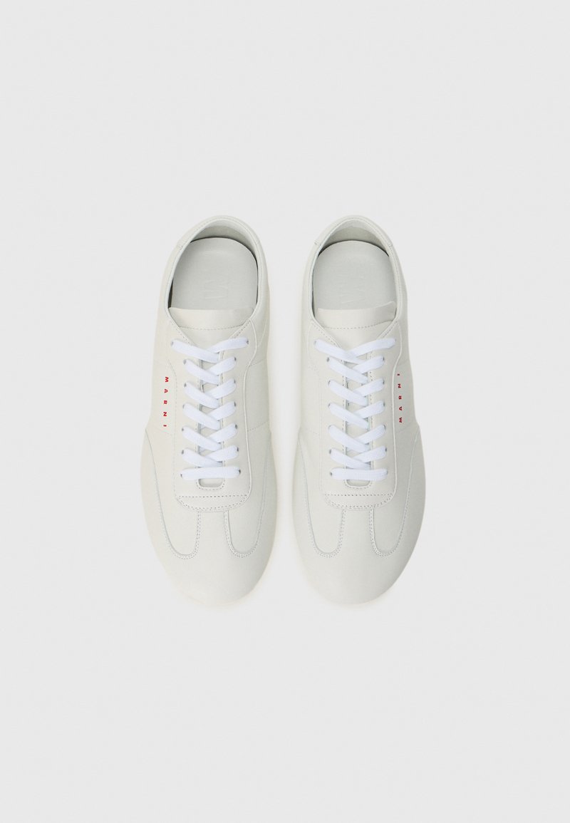 Een paar witte leren sneakers met witte veters en rode "MARNI" branding aan de buitenzijden, van bovenaf weergegeven op een witte achtergrond.