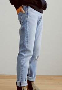 Lichtblauwe denim jeans met een relaxed fit, opgerolde boorden en subtiele vervaging. Bevat een klassiek vijf-pocket ontwerp en zichtbare stiksels.