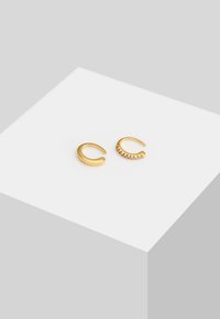 Guldøreringe med et glat, afrundet cuff-design og en anden cuff med små, dekorative ædelsten langs den øverste kant.