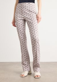 Strakke roze broek met ingewikkelde zwarte bloemenpatronen, met een hoge taille en een rechte pasvorm. Gladde textuur met zijnaad.