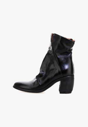 Crne kožne čizme do članaka s naboranim dizajnom, šiljastim prstima i umjerenim potpeticama; imaju suptilni sjaj i minimalno šivanje.