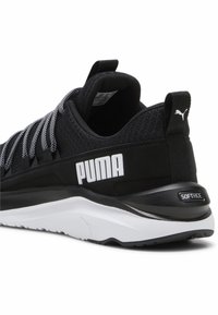 Fekete sportcipő hálós felsőrésszel, fehér fűzőkkel és nagy "PUMA" logóval. Fekete és fehér talp, "SOFTRIDE" részletekkel.