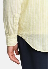 Geel gestreept overhemd met lange mouwen, gemaakt van lichtgewicht stof, met een knoopmanchet en een gebogen zoom. Slim-fit ontwerp, zachte textuur.