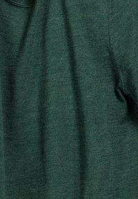 Groene trui gemaakt van een gestructureerde gebreide stof. Het heeft een ronde hals en subtiele ribbels langs de randen, wat een casual uitstraling creëert.