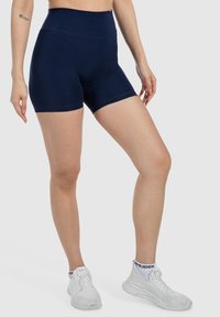 Shorts atletici a vita alta di color blu navy realizzati in materiale elastico, con una texture liscia e un design aderente.