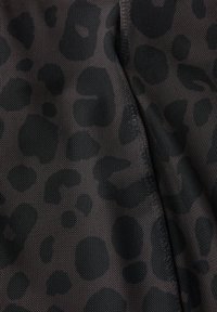 Tissu en maille noir présentant un subtil motif léopard foncé et une surface texturée, avec des coutures visibles le long des bords.