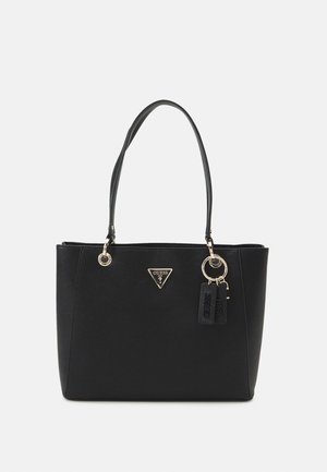 Sac à main noir Guess avec deux poignées, ferrures dorées, logo triangulaire et deux étiquettes suspendues sur un fond uni.