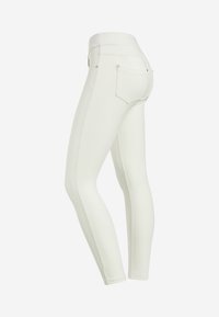Leggings bianchi aderenti con una texture liscia, vita media e tasche posteriori, caratterizzati da dettagli di cuciture a contrasto lungo i lati.