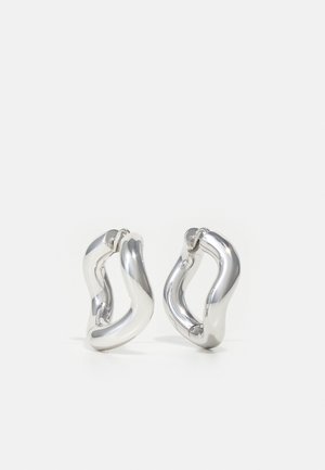 Cercei argintii sub formă de inele, cu o formă răsucită și organică, având o suprafață strălucitoare și reflectorizantă. Fără modele sau accente vizibile.