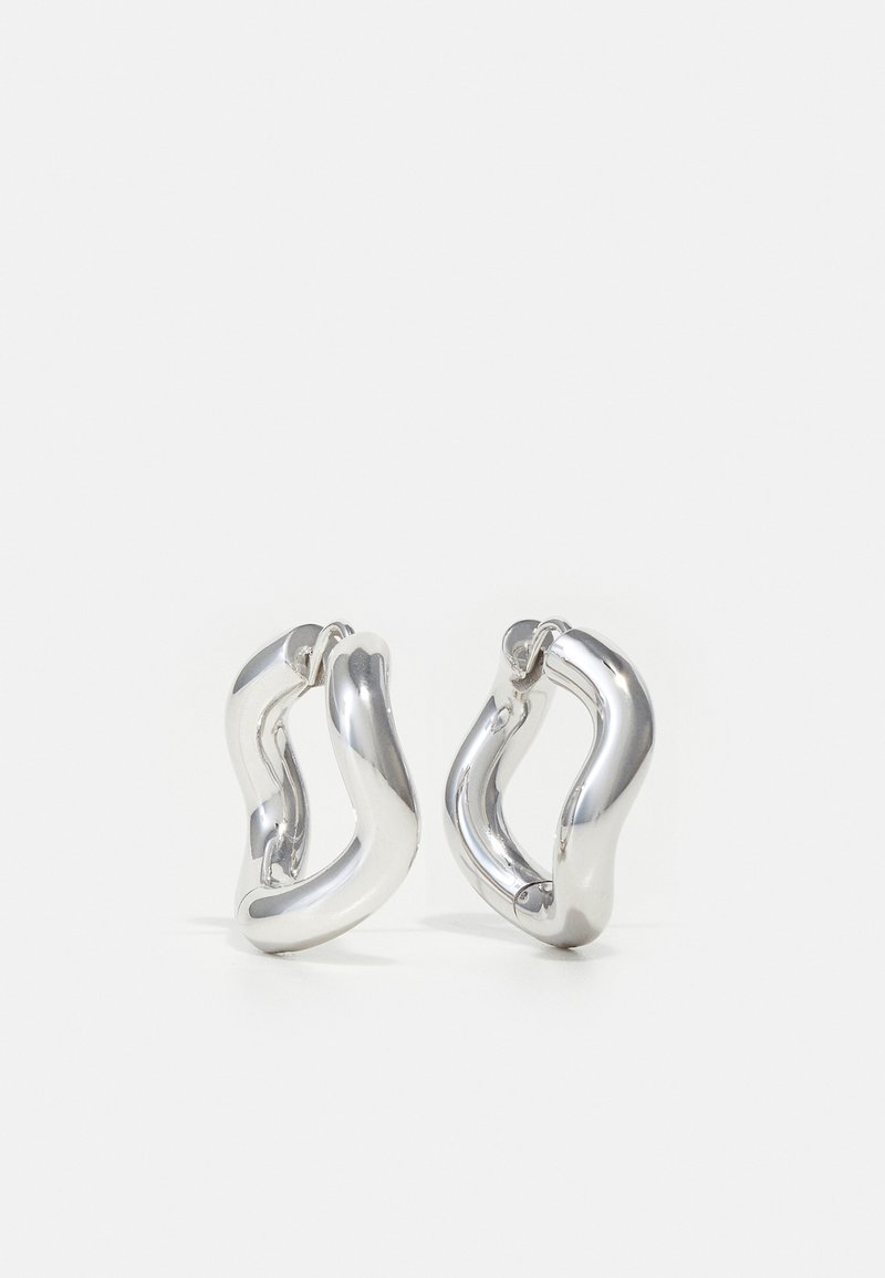 Hõbedased rõngas kõrvarõngad keeruka, orgaanilise kuju ja läikiva, peegelduva pinnaga. Ilma nähtavate mustrite või aktsentideta.