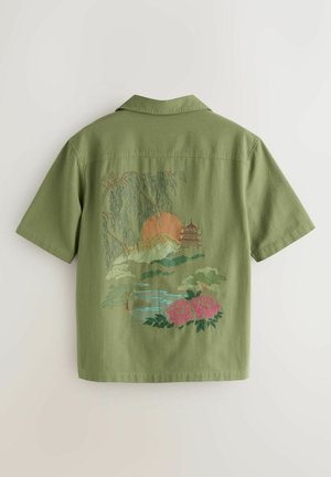 Trumpomis rankovėmis žalia marškinėliai su sudėtingu siuvinėtu peizažo dizainu, kuriame pavaizduoti kalnai, saulė, pagoda ir rausvos rožės.