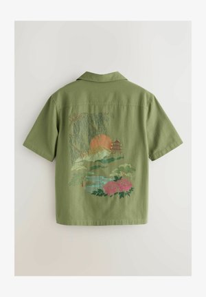 Grön t-shirt med korta ärmar som har en intrikat broderad landskapsdesign med berg, en sol, en pagod och rosa rosor.