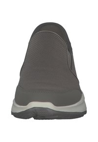 Zapato slip-on de malla gris con una punta lisa y redondeada y un diseño minimalista. Presenta una suela blanca en contraste y una parte superior texturizada.